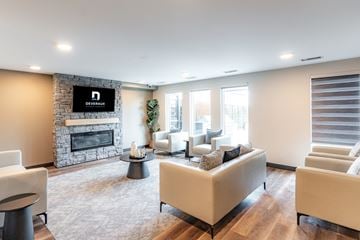 Edmonton apartment for rent - A living room with a stone fireplace and a television above it.