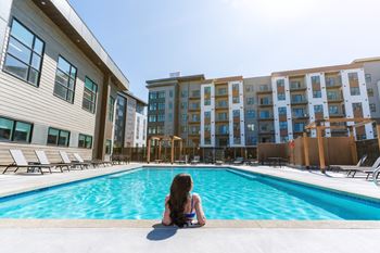 A woman sits on the edge of a pool