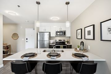 Winnipeg apartment for rent - A modern kitchen with a dining table set for four.