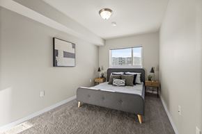 Regina apartment for rent - A bedroom with a bed, nightstands, and a window.