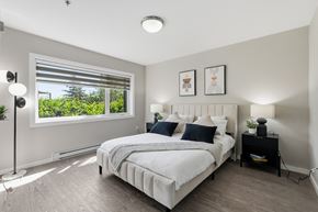 Winnipeg apartment for rent - A bedroom with a large bed and a window with blinds.