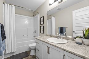 Regina apartment for rent - A bathroom with a white toilet, sink, and bathtub.