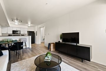 Regina apartment for rent - A modern living room with a black coffee table and a flat screen TV.