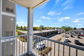 Regina apartment for rent - A balcony overlooks a parking lot and buildings.