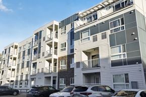 Regina apartment for rent - A modern apartment building with cars parked in front.
