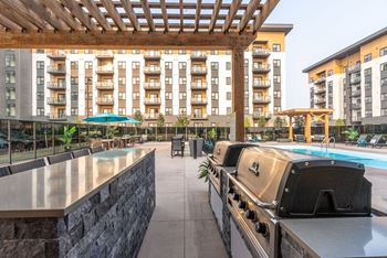 A patio with a grill and a swimming pool