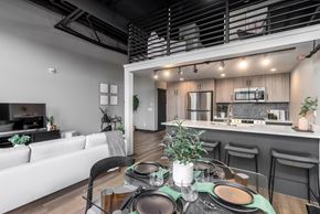 Edmonton apartment for rent - A modern dining area with a table set for a meal.at Raymond Block, Edmonton, T6E 3R7