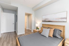 Sherwood Park apartment for rent - A bedroom with a large bed and a painting on the wall.