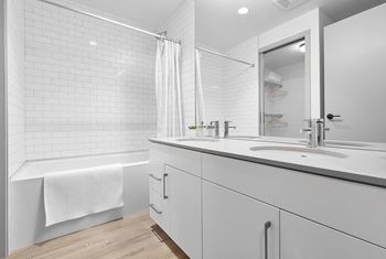 A white bathroom with a white tub, sink, and shower.