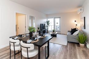 Calgary apartment for rent - A modern dining room with a black table and white chairs.at Vibe Apartments at Arbour Lake, Calgary