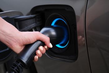 A hand holding a gas pump nozzle