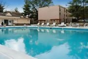 Lanham apartment for rent - A swimming pool with lounge chairs and a building in the background.
