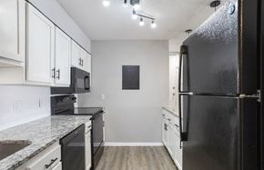 Hoover apartment for rent - A black refrigerator is on the right side of a kitchen at The Onyx Hoover Apartments, Hoover, AL