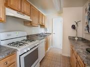Lanham apartment for rent - a kitchen with wooden cabinets and a white stove top oven at The Glendale Residence, Lanham, MD