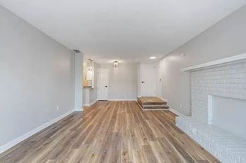 A room with wooden flooring and white walls.