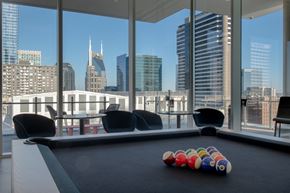 Nashville apartment for rent - A pool table with a set of balls on it in front of a city skyline.