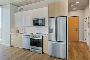Nashville apartment for rent - a kitchen with white cabinets and stainless steel appliances and a refrigerator