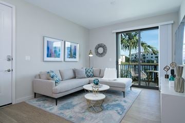 Fort Myers apartment for rent - a living room with a couch and a coffee table and a door to a balcony