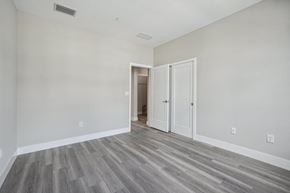 Naples townhouse for rent - an empty bedroom with white walls and wood flooring