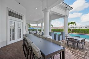 Naples townhouse for rent - A white building with a pool in the background at The Falls of Portofino Apartment, Naples, Florida