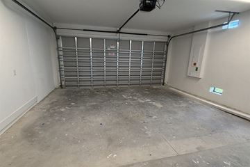 Fort Myers townhouse for rent - A garage with a closed metal gate and a concrete floor.