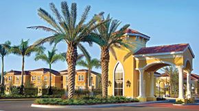 Hollywood condo for rent - A yellow building with palm trees in front.