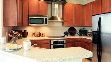Hollywood condo for rent - A kitchen with brown cabinets and a white countertop.