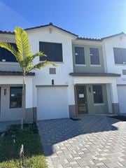 Fort Myers apartment for rent - A white house with a green door and a palm tree in front.