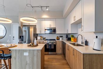 A modern kitchen with wooden cabinets and a white island.