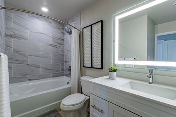 A white bathroom with a toilet, sink, and a shower.