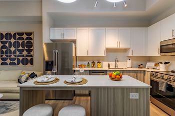 A modern kitchen with a dining table set for two.