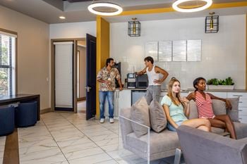 Four people are sitting on a couch in a modern living room
