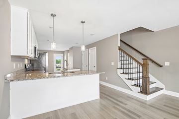 Lebanon apartment for rent - A kitchen with a marble countertop and a staircase with a wooden handrail.