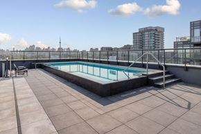 Toronto apartment for rent - a rooftop swimming pool on the top of a building with a city in the background