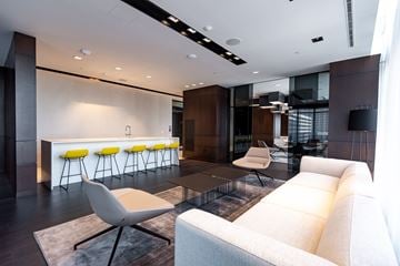 Toronto apartment for rent - A modern living room with a white sofa and yellow bar stools.