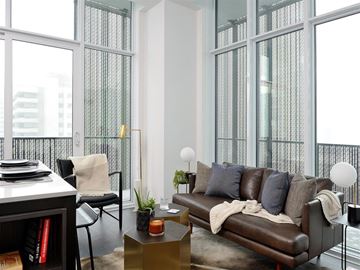 Toronto apartment for rent - A living room with a brown couch and a large window.