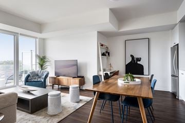 Ottawa apartment for rent - A modern living room with a wooden dining table and blue chairs.