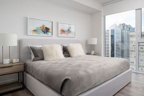 Toronto apartment for rent - A bedroom with a large bed and two framed pictures on the wall.