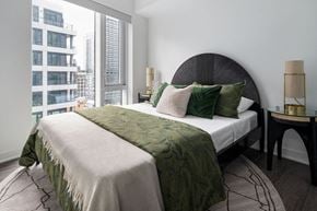 Toronto apartment for rent - a bedroom with a bed and a large window