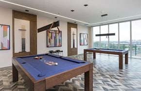 York apartment for rent - a games room with two pool tables and views of a city
