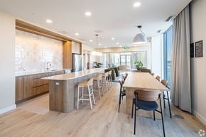 Ottawa apartment for rent - A modern kitchen with a long wooden table and chairs.