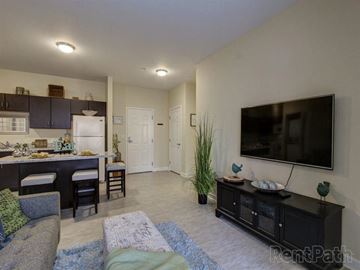 Brunswick apartment for rent - A living room with a grey couch and a black cabinet.