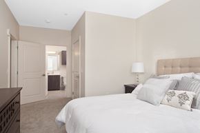 Malden apartment for rent - A bedroom with a large bed and a nightstand with a lamp.