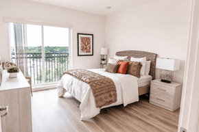 Aurora apartment for rent - A bedroom with a large bed and a view of the balcony.