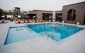 Columbus apartment for rent - a swimming pool with chairs around it in front of a building