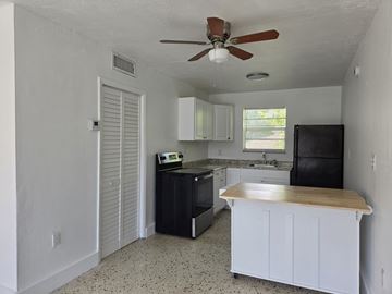 Miami apartment for rent - A kitchen with black appliances and white cabinets.