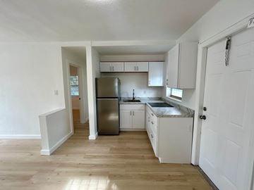 Miami apartment for rent - A kitchen with white cabinets and a stainless steel refrigerator.