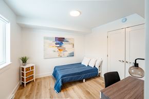 Dieppe apartment for rent - A bedroom with a blue bed and a painting on the wall.