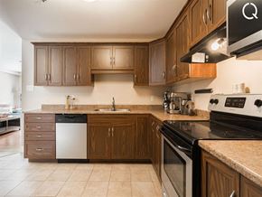 Dieppe apartment for rent - a kitchen with wooden cabinets and black appliances