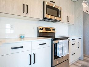 Dieppe apartment for rent - a kitchen with white cabinets and a stove and a microwave